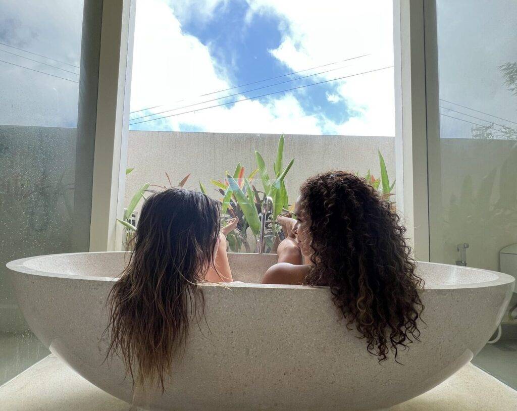 2 femmes dans un bain qui se regardent et mettent en avant leurs cheveux